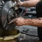 mani sporche di grasso aggiustano il cerchione di una ruota